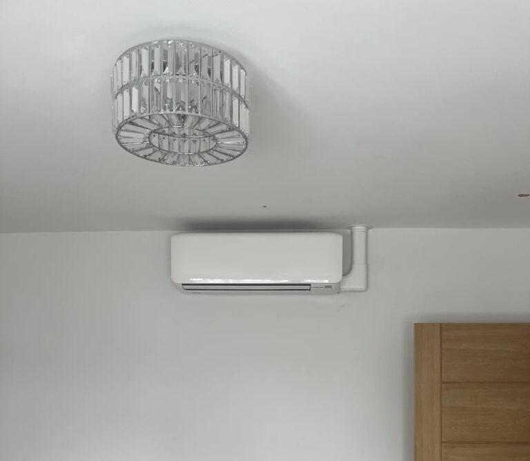 Ceiling light and air conditioning unit on wall