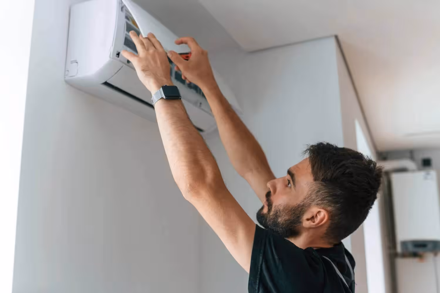 Man fixing a wall-mounted air conditioner