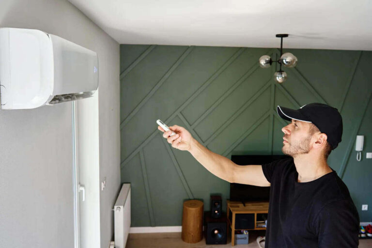 Man adjusting air conditioner with remote