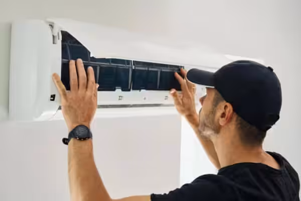 Technician repairing an air conditioning unit.