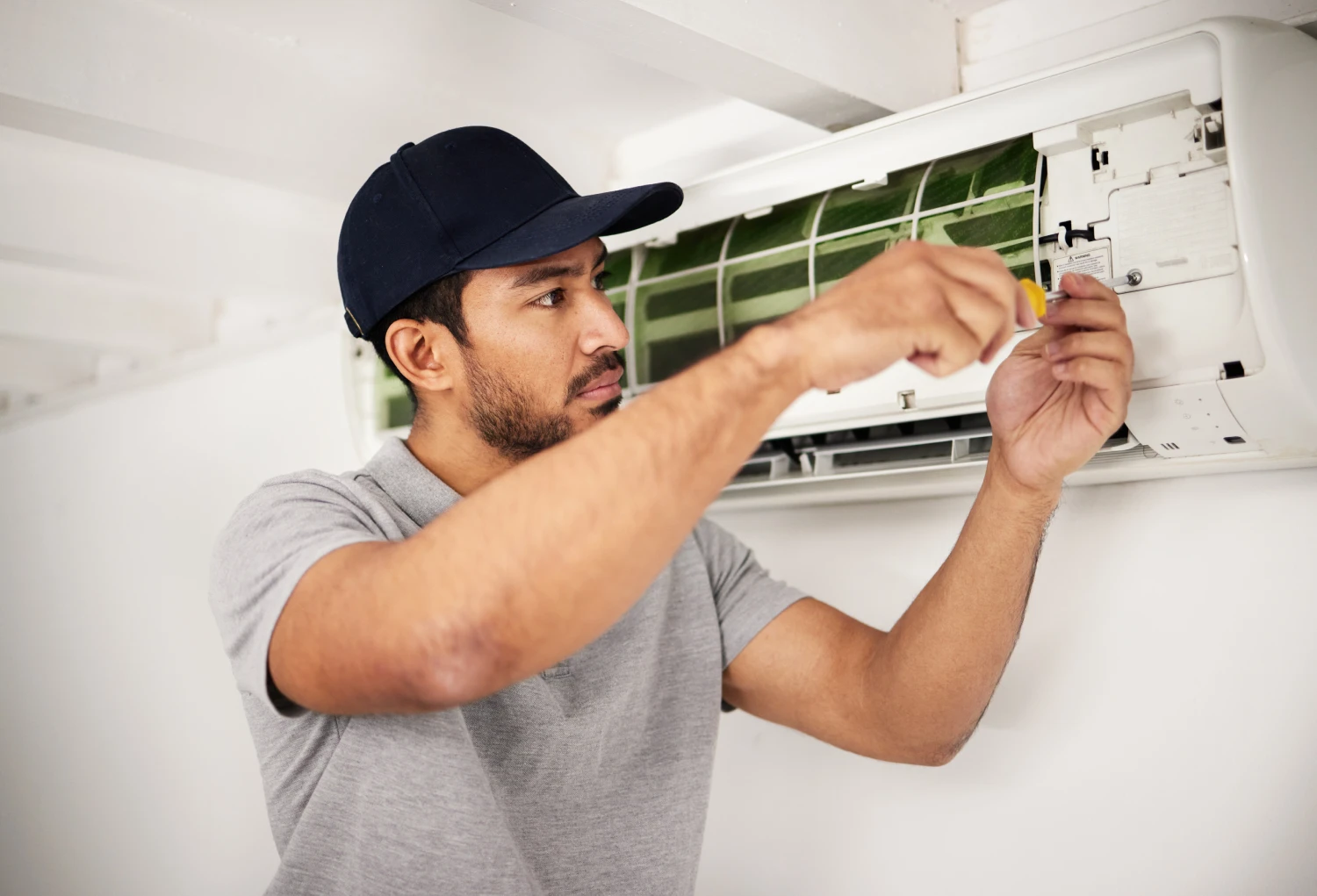 Technician repairing wall-mounted air conditioner unit