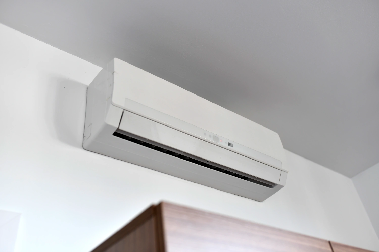 Wall-mounted air conditioning unit near ceiling
