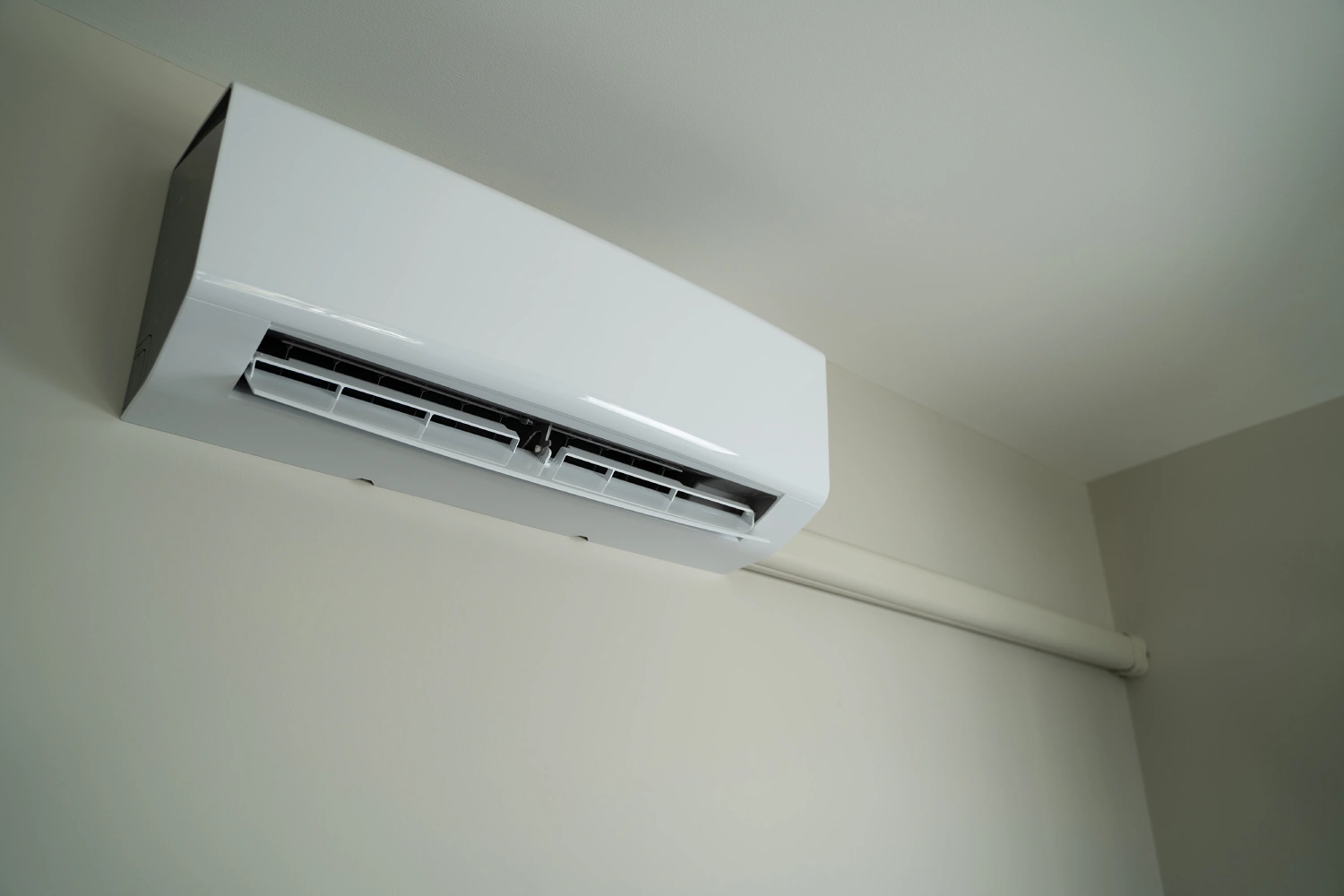 Wall-mounted air conditioning unit near ceiling