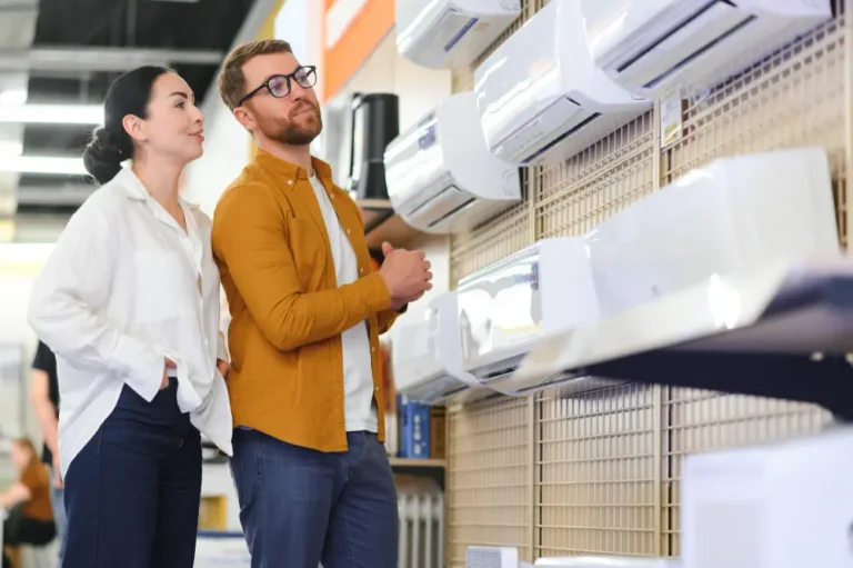 Couple comparing wall-mounted air conditioners in appliance shop